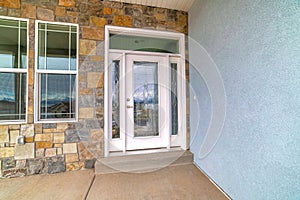 Elegant glass front door with sidelights and transom window at house facade