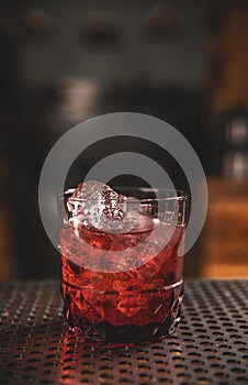 Elegant glass of red cocktail on bar counter