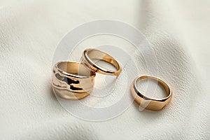 Elegant golden rings on fabric. Stylish bijouterie