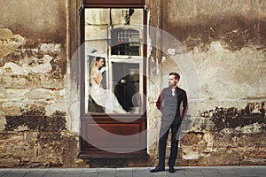 Elegant gorgeous bride drinking coffee in window and stylish gr