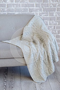 The elegant handmade blanket lies on the sofa