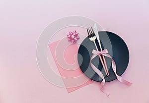 Elegant holiday table place setting with card and cutlery closeup on pink
