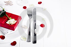 Elegant holiday table setting with red ribbon gift