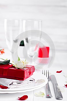 Elegant holiday table setting with red ribbon gift