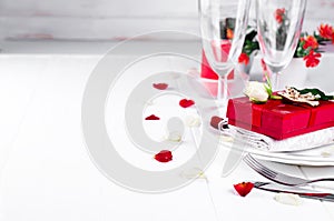 Elegant holiday table setting with red ribbon gift