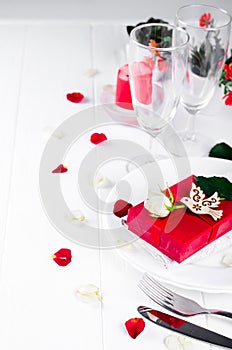 Elegant holiday table setting with red ribbon gift