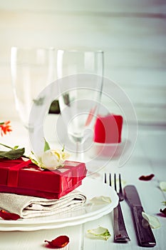 Elegant holiday table setting with red ribbon gift