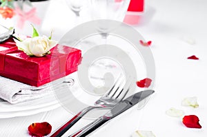 Elegant holiday table setting with red ribbon gift