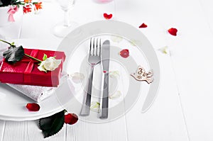 Elegant holiday table setting with red ribbon gift