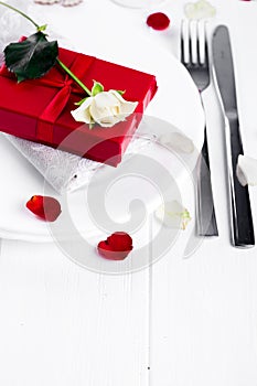 Elegant holiday table setting with red ribbon gift