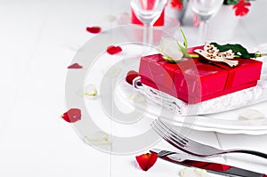 Elegant holiday table setting with red ribbon gift