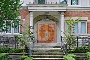 Elegant home entrance with wood grain double door and portico