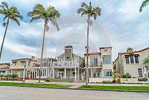 Elegant houses along road lined with tall palm trees in Long Beach California