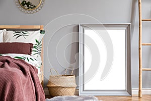 Elegant interior of bedroom with design furnitures, mock up poster frame, mirror, decoration, blanket, pillows.
