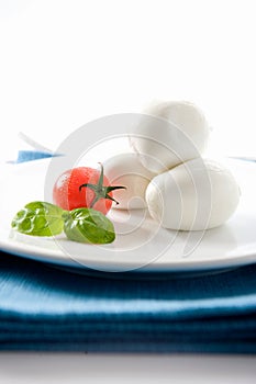 Elegant Italian dish with a DOP buffalo mozzarella from Campania and tomato with basil on a white background and pla