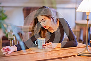 Elegant lady in a black dress, in a restaurant alone. Girl in a cafe in a black dress