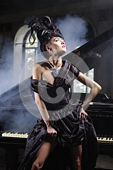 Elegant lady with luxurious hairstyle near piano