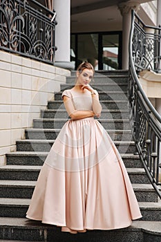 Elegant lady satnd on stairs in front of restaurant