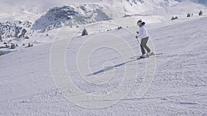 Elegant lady skier professionally carving down the slope in the mountains