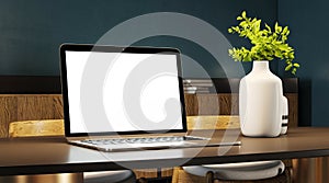 Elegant laptop setup with decorative vases and plants on a wooden desk, modern office design.