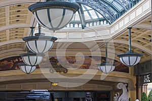 Elegant lights hanging from the ceiling in front of the Bellagio Hotel and Resort with a colorful wall mural in Las Vegas Nevada