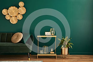 Elegant living room interior with modern design, green velvet sofa, furniture, gold decoration, plant, carpet, copy space, pillow