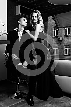 an elegant loving couple is in a restaurant. black and white photo