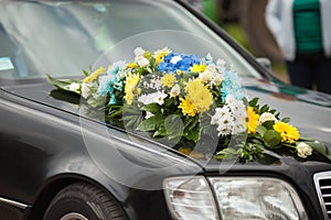 Elegant luxury black car decorated with yellow and blue flowers