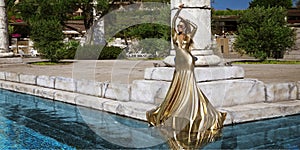 Elegant luxury evening fashion. Glamour, stylish elegant woman in golden long gown dress is posing in luxury hotel outdoor. Female