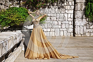 Elegant luxury evening fashion. Glamour, stylish elegant woman in long gown dress is posing outdoor in luxury resort in Turkey.