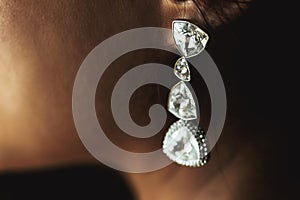 Elegant luxury wealthy wedding diamond earrings on beautiful bride closeup