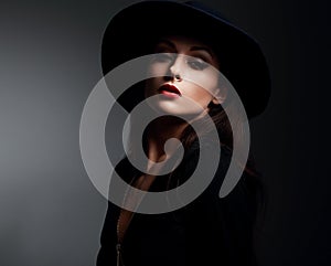 Elegant makeup woman in fashon hat and red lips posing on dark s