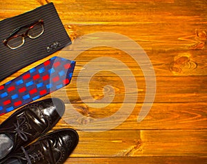 The elegant male set: men`s shoes, suit, tie on wooden background.
