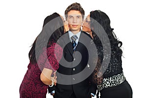 Elegant man being kissed by two women photo