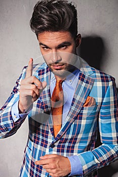 Elegant man in checkered suit gesturing for you to behave photo