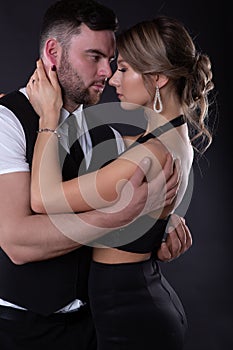 Elegant man embraces his sexy woman who closed her eyes with pleasure