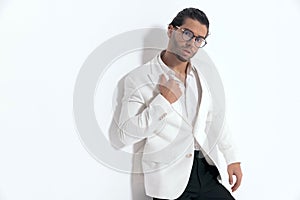 elegant man with glasses pulling and adjusting white jacket suit