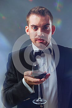 Elegant man holding a glass of red wine