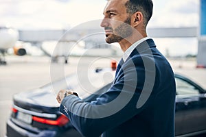 Elegant man lifting his left hand to check the time