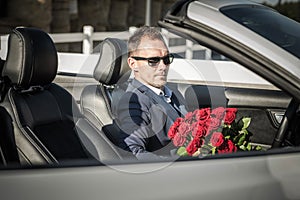 Elegant Man with Red Roses Awaiting His Date