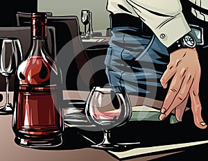 Elegant man's hand next to a glass of brandy. photo