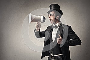 Elegant man screaming into a megaphone photo