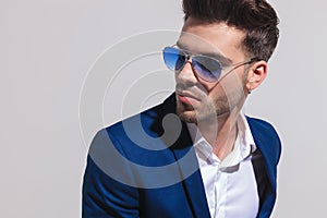 Elegant man in sunglasses looking away to side