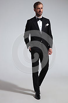 Elegantní muž v smoking stojící ruka v kapsa 