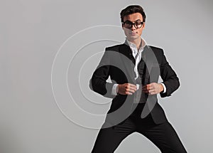 Elegant man wearing glasses unbuttoning his tuxedo