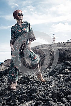 Elegant mature woman in a coastal area near a lighthouse