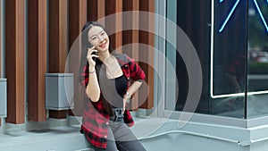 Elegant millennial woman talking on phone at city mall, happy conversation