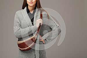 Elegant model in gray woven cardigan with a leather fanny pack