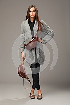 Elegant model in gray woven cardigan with two leather fanny pack