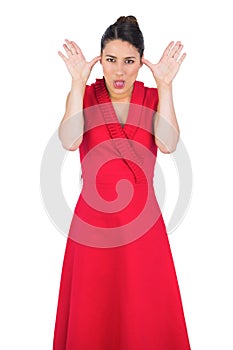 Elegant model in red dress making faces
